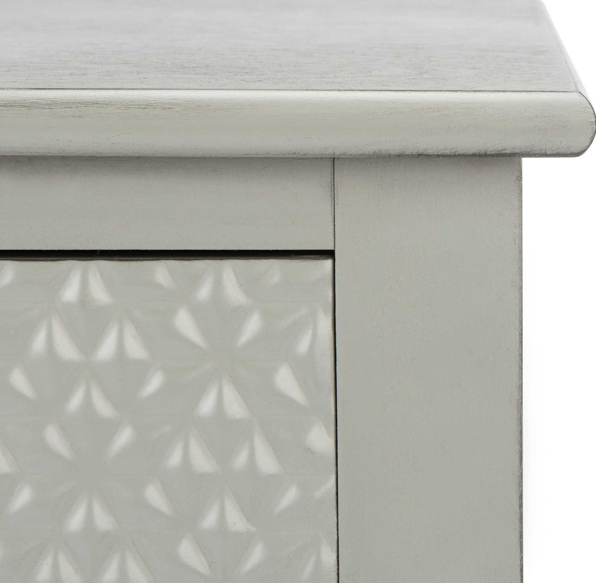 A softly rounded tabletop edge complements the distressed gray finish and raised geometric drawer pattern