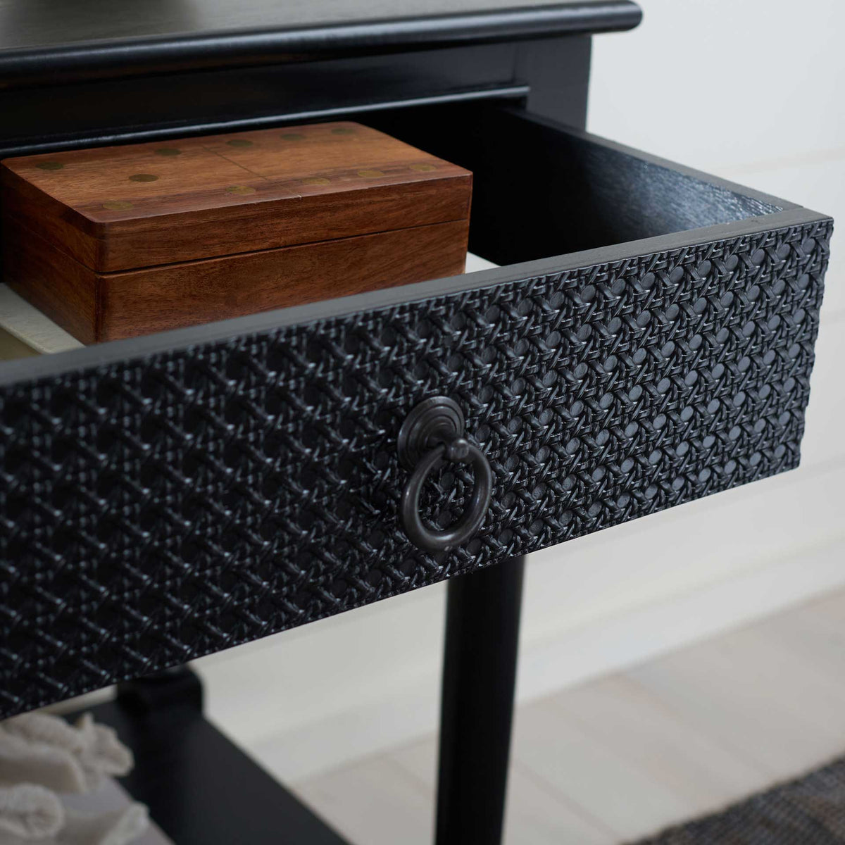 An open drawer offers easy access to small keepsakes beneath the black tabletop.