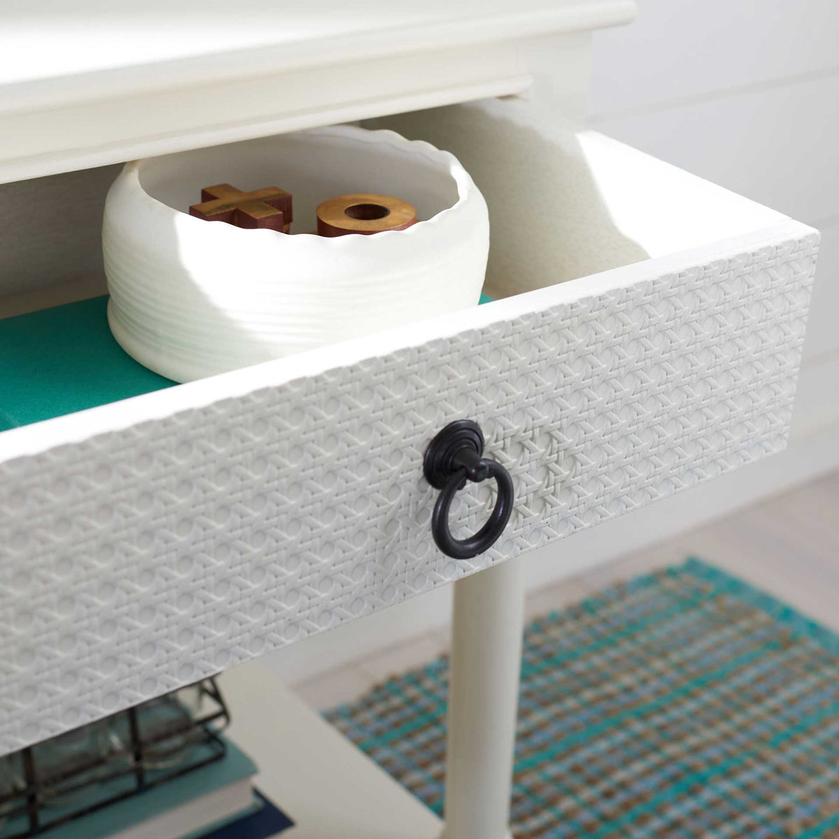 The open drawer keeps small essentials close, with a dark ring pull on its textured white front.
