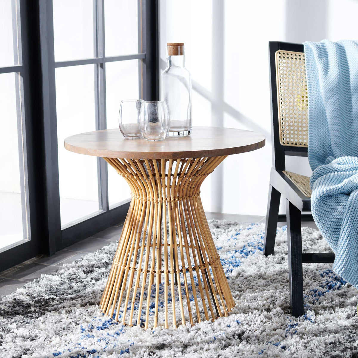 Natural wood and golden brown rattan bring breezy warmth beside a cane-back chair.