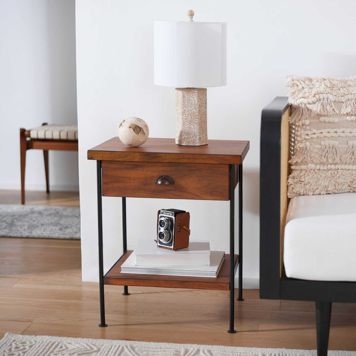 A warm wood drawer and open shelf keep essentials within reach beside a sofa.