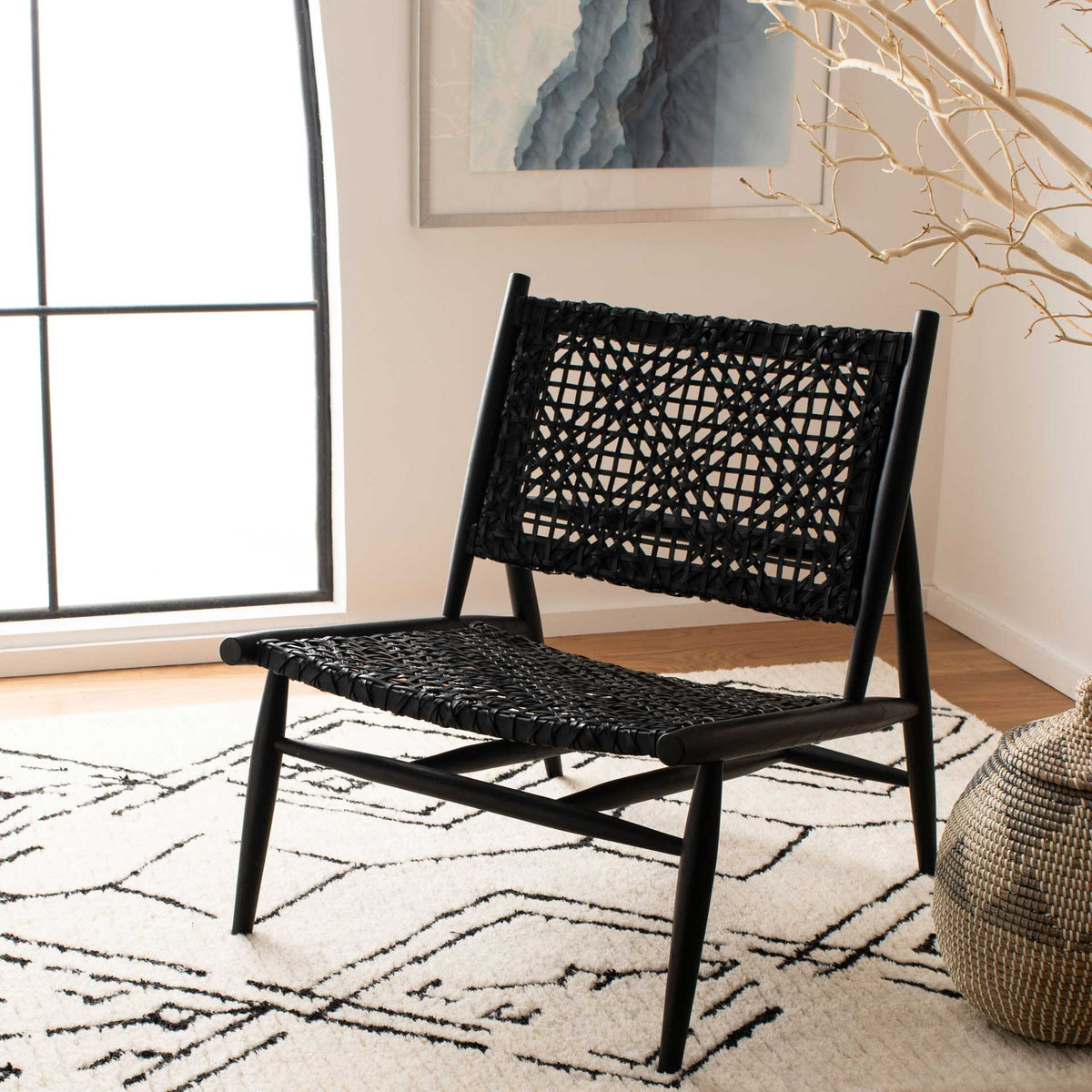 This low black woven leather chair brings bold texture and relaxed seating to a bright interior.
