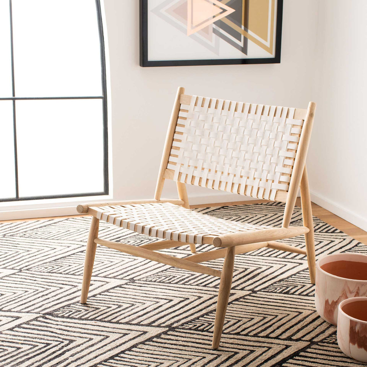 White leather and natural wood brighten a broad lounge seat with Scandinavian simplicity