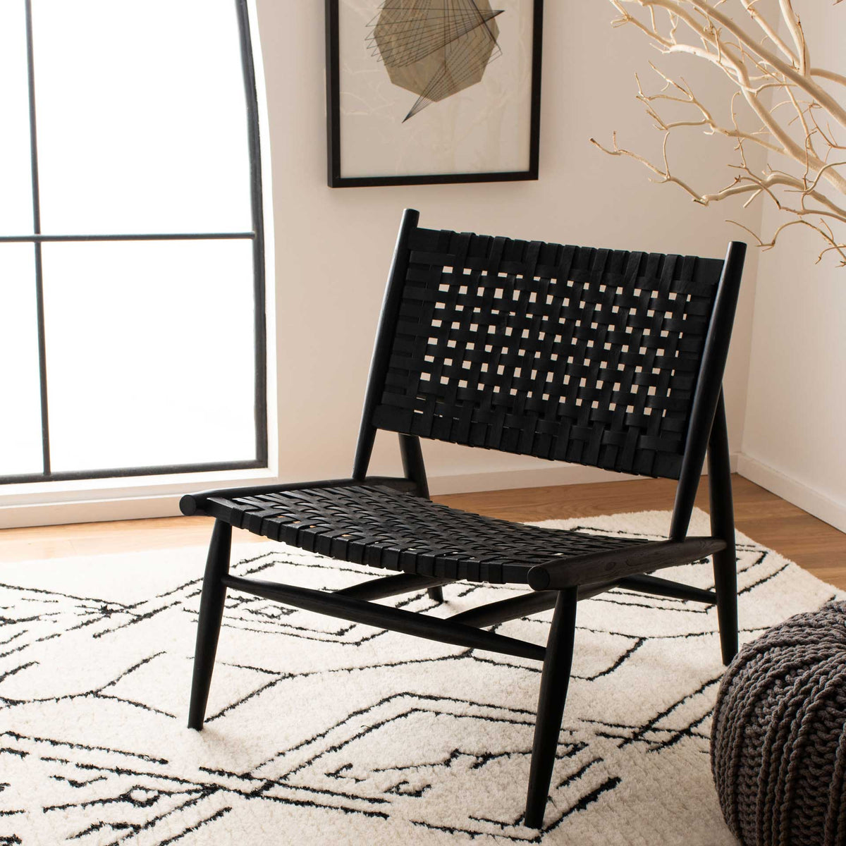Black woven leather adds graphic texture to an inviting chair with slim wooden legs