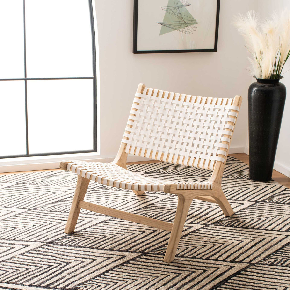 An airy white leather weave and light wood frame brighten a relaxed living room.