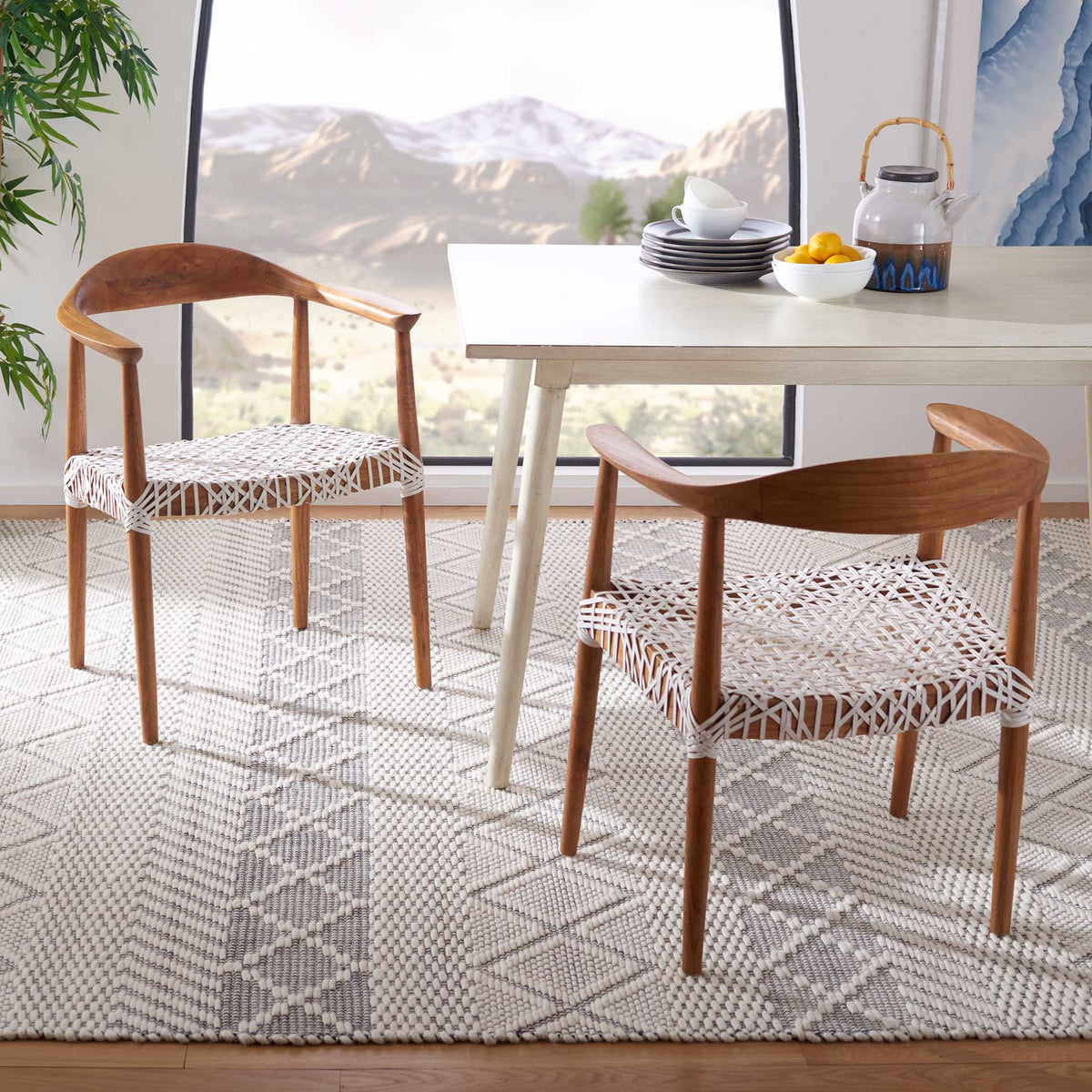 Natural wood chairs with woven white leather seats lend relaxed texture to a dining space.