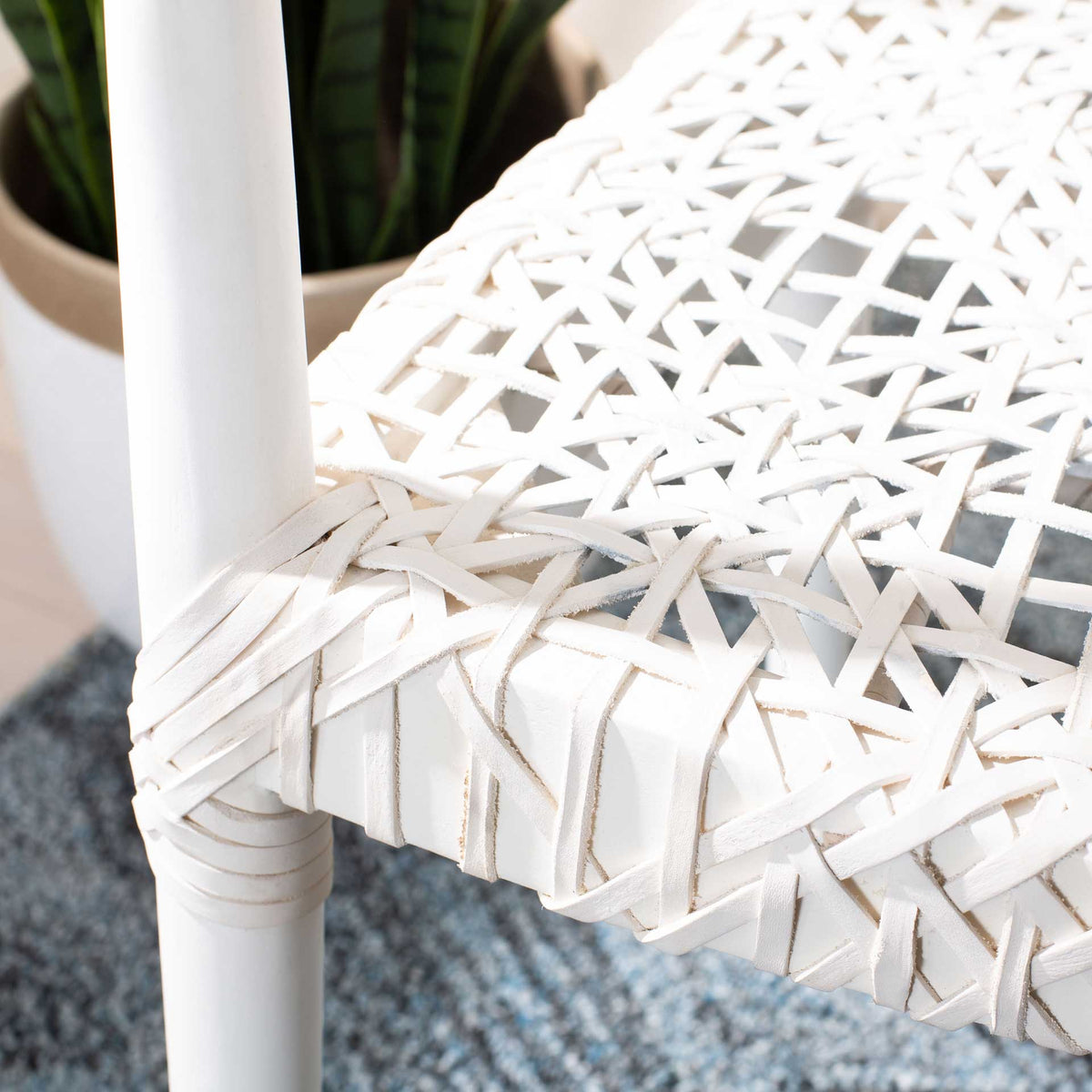 A crisscross white leather seat wraps over the white frame for texture and detail.