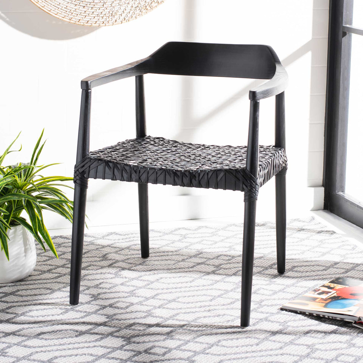 All-black wood and woven leather add graphic texture to this airy accent chair