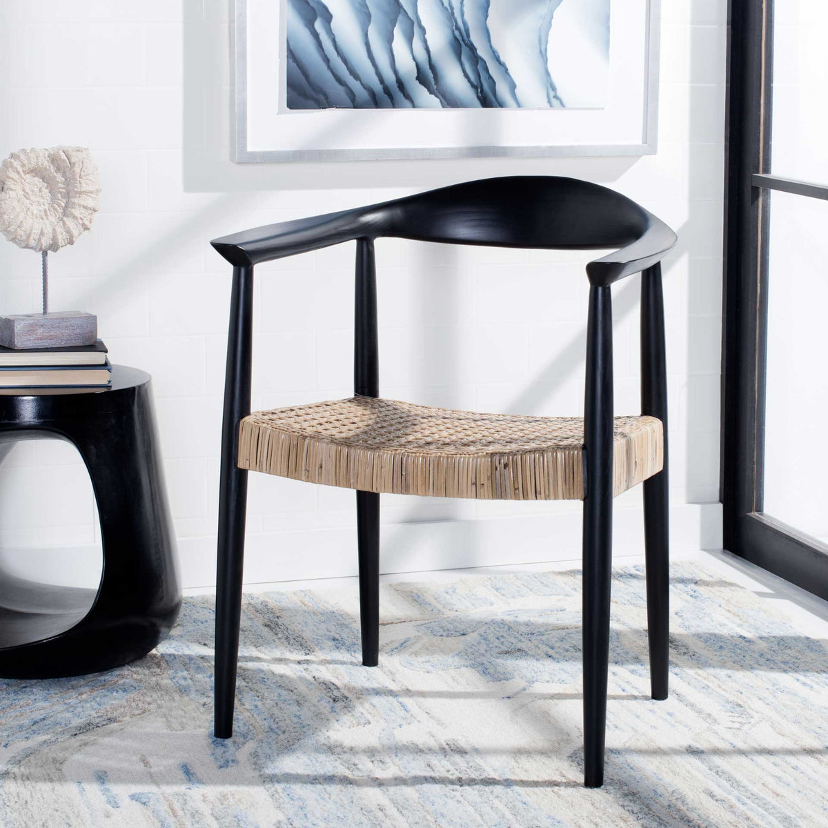 Retro-inspired black wood chair with a woven natural rattan seat adds warmth to a bright space