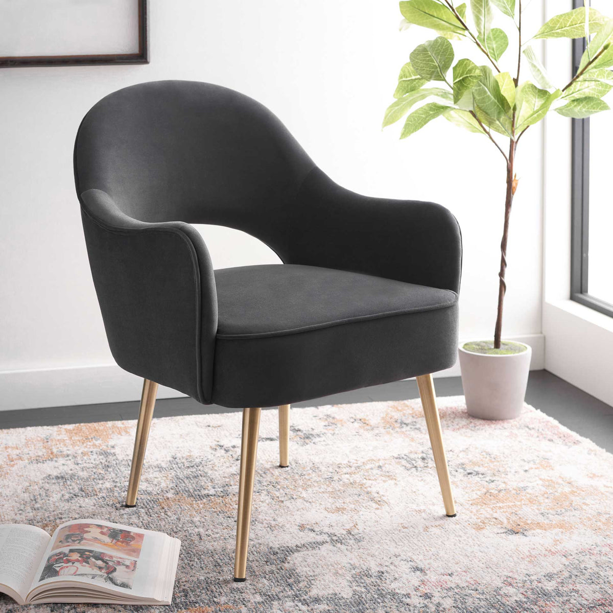 Curved black velvet and tapered gold legs give this accent chair modern elegance