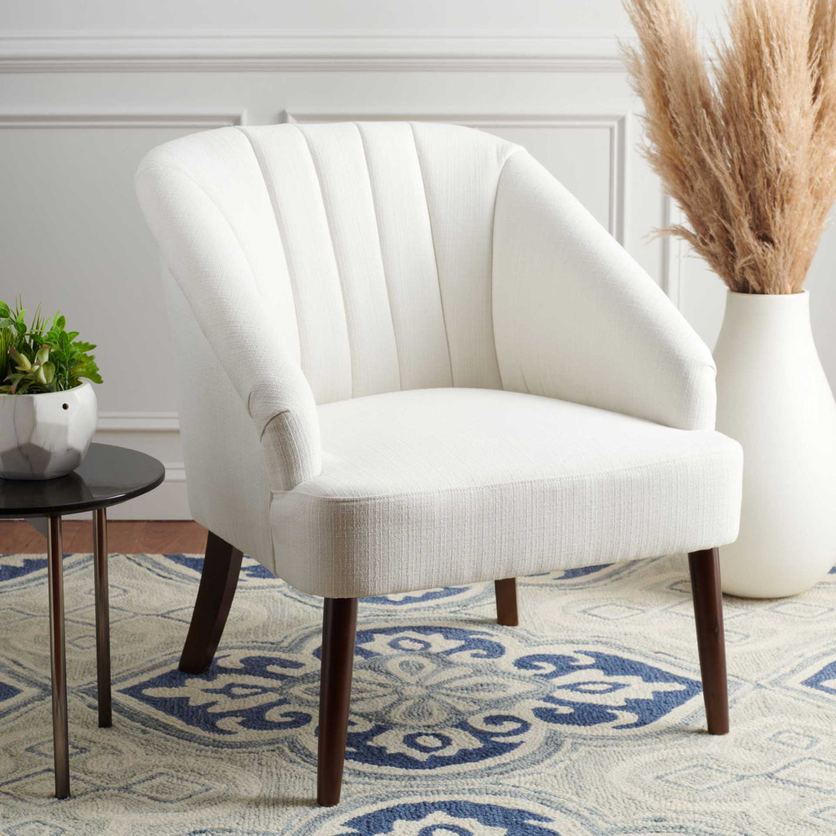 Soft white upholstery and vertical channel tufting lend texture to a sculpted accent chair
