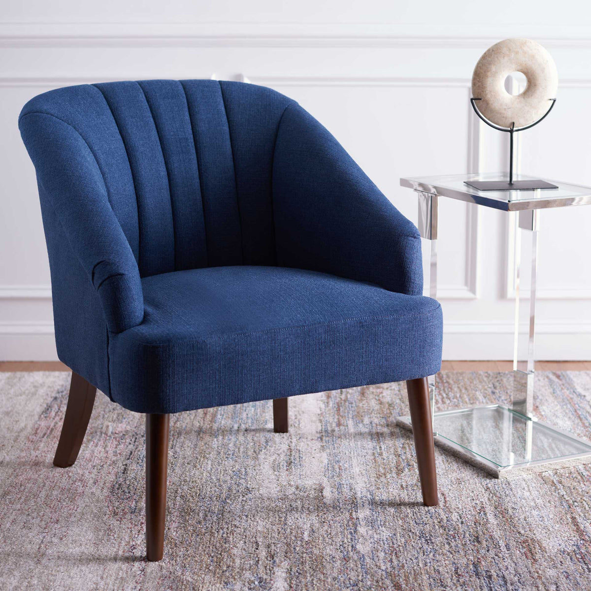 Sculpted navy arms and vertical channel tufting give this cushioned accent chair inviting style