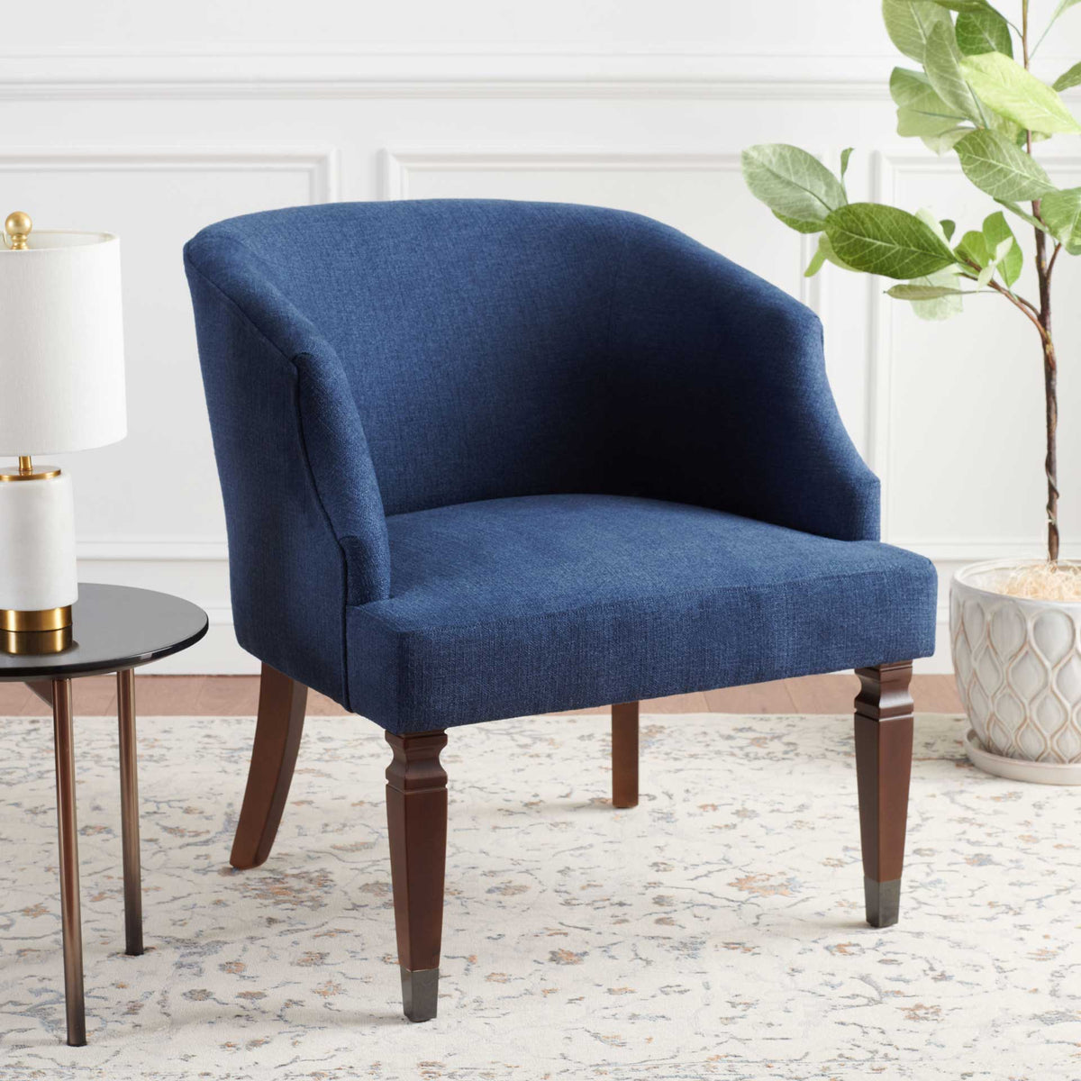 Deep navy upholstery, a cushioned seat and curved arms make this wood-legged chair an inviting accent.
