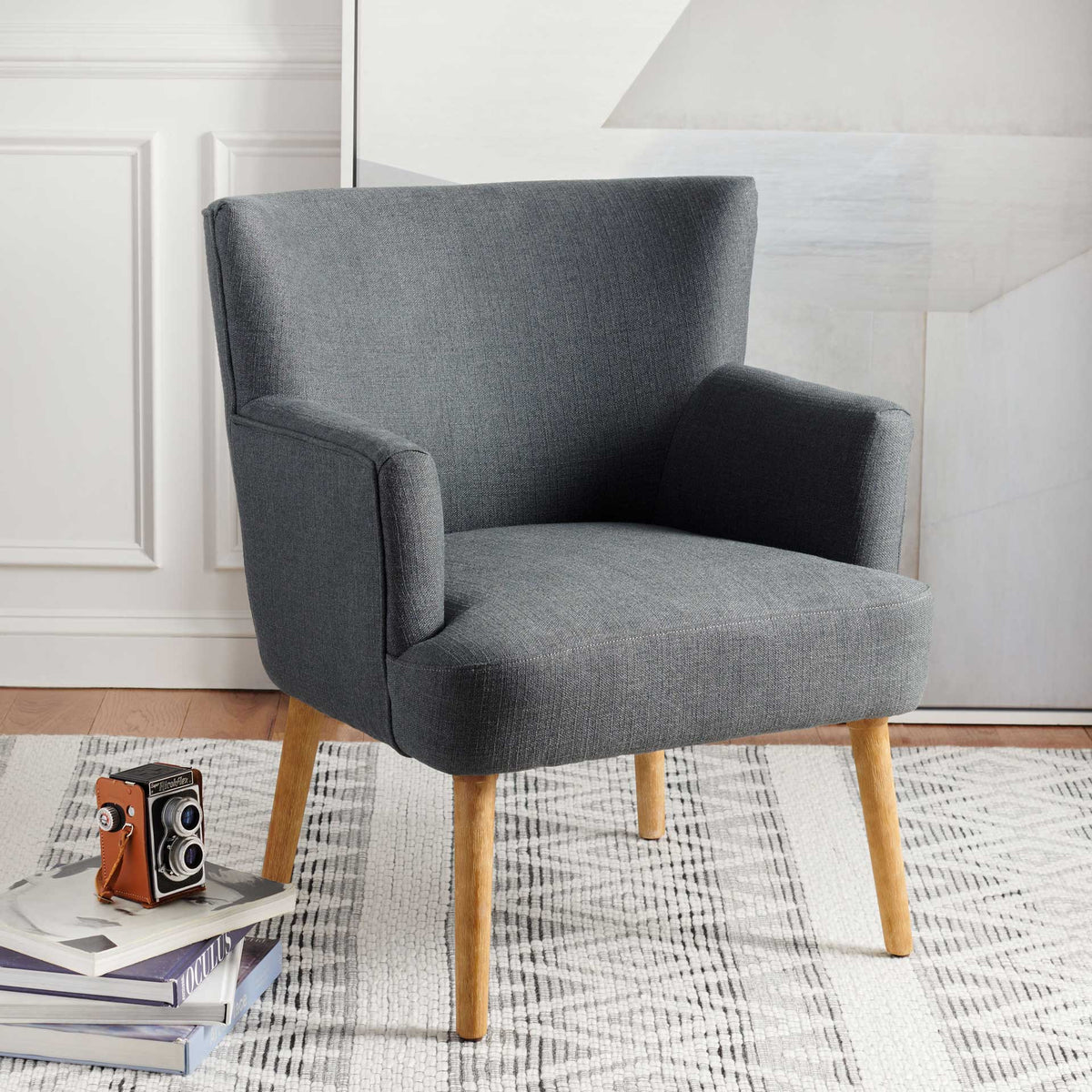 Dark gray upholstered accent chair brings cozy texture and light wood legs to a modern space