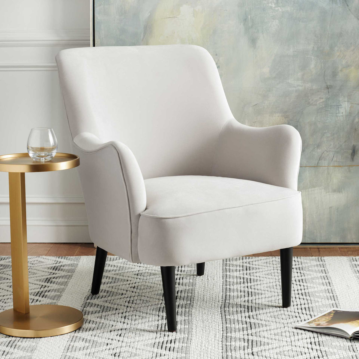 Light gray velvet chair offers a plush seat, curved arms, and a graceful contoured back