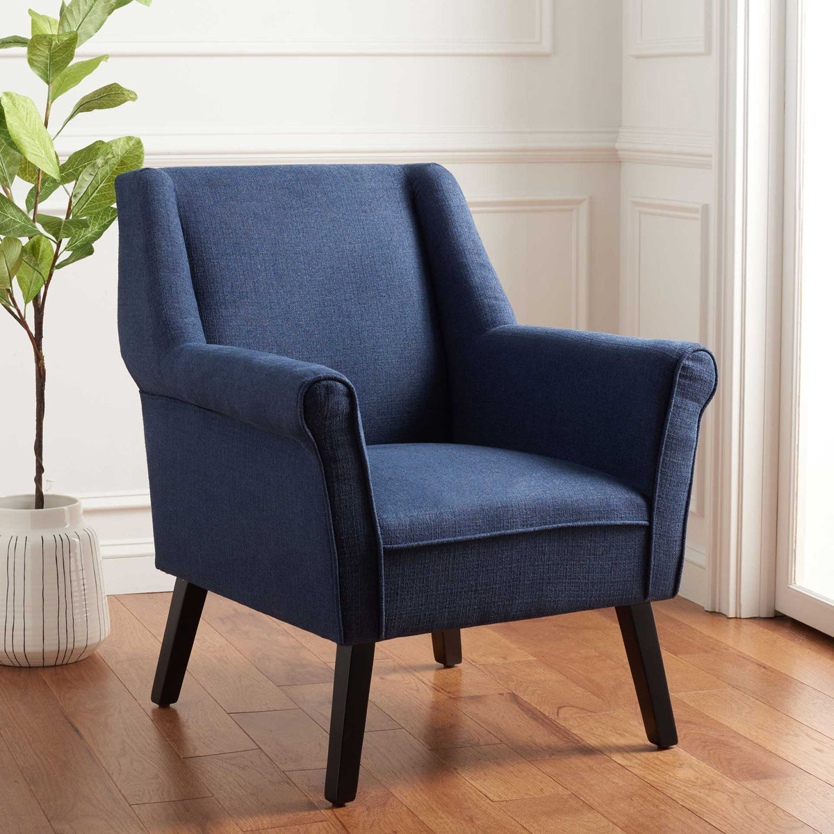 Deep navy upholstery gives this enveloping chair a rich look, accented by rolled arms and slim black legs