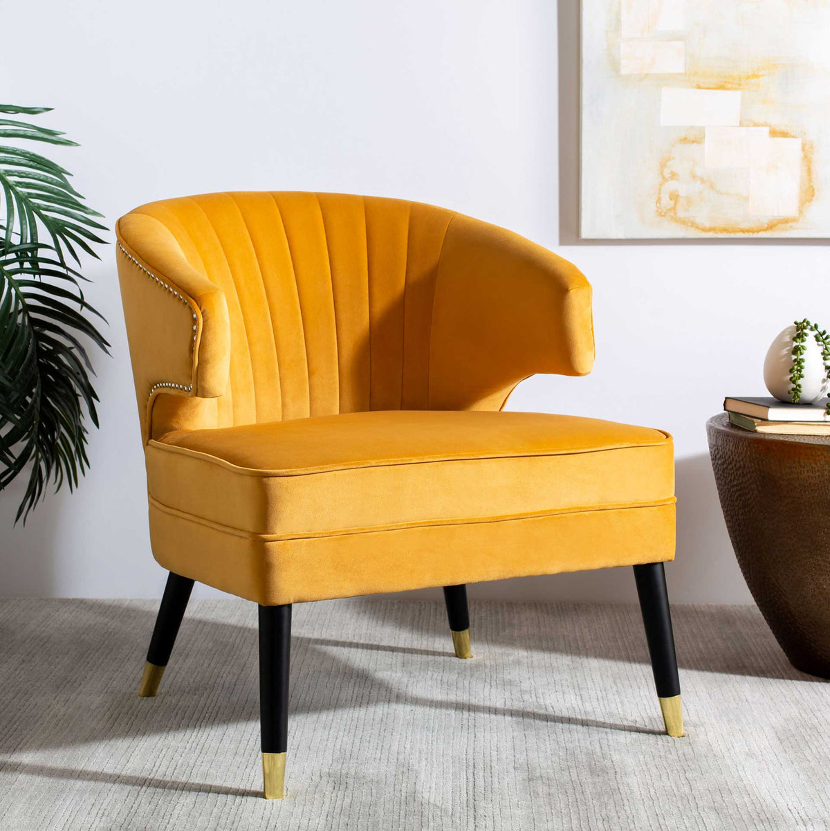 A vibrant marigold velvet chair brings plush channel tufting and gold accents to the living room.