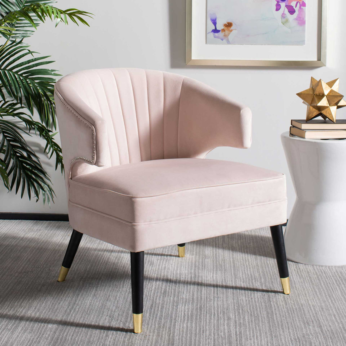 Blush pink velvet, gentle channel tufting, and gold-tipped legs bring softness to a modern living room.