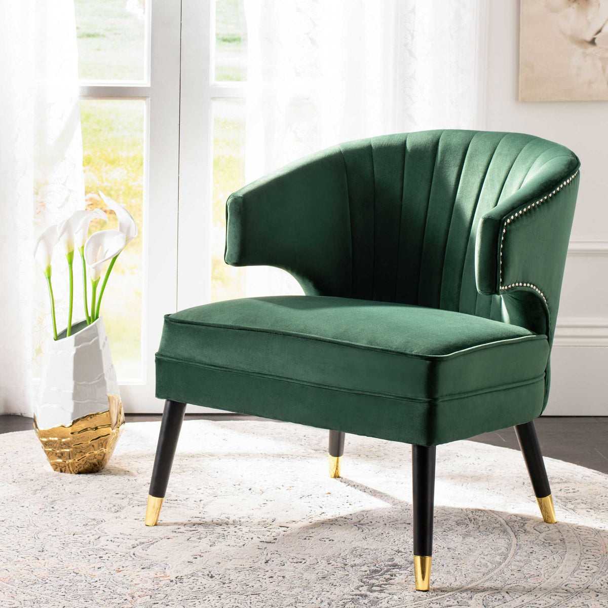 Forest green velvet, graceful channel tufting, and gold-tipped legs add elegance to a bright living space.