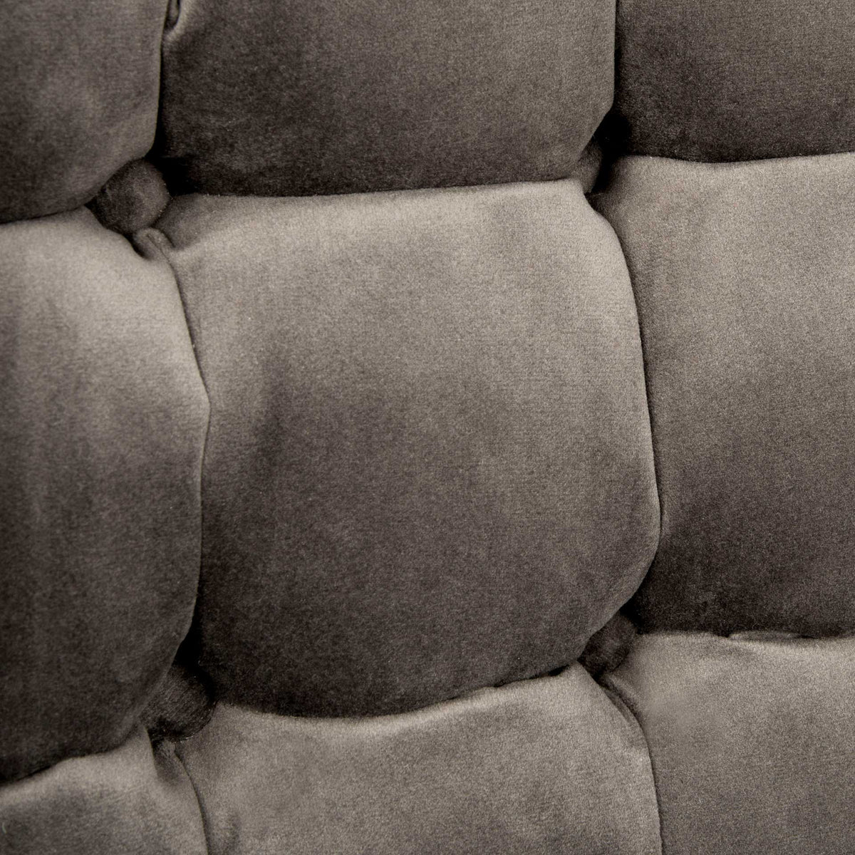 Soft shale gray velvet surrounds deep tufts for a richly textured, cushioned surface.