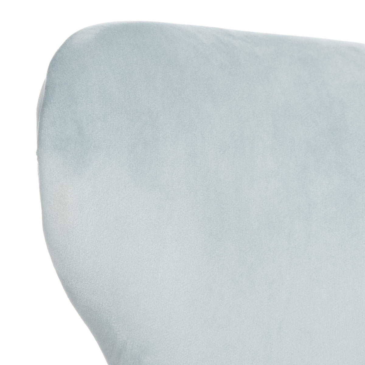 Pale blue velvet lends a soft texture to the rounded, gently curved wingback