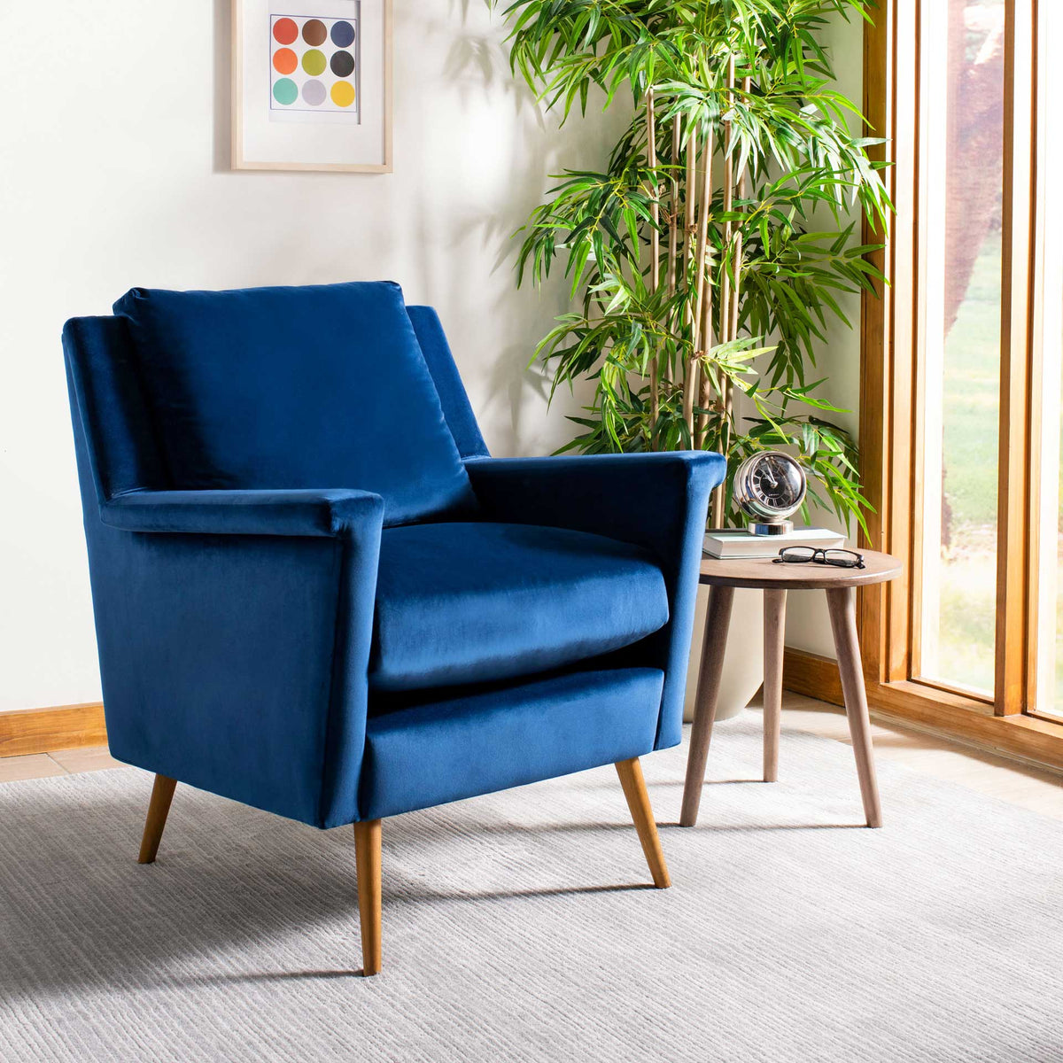 Navy velvet armchair creates a cozy reading spot with soft cushions and warm oak legs