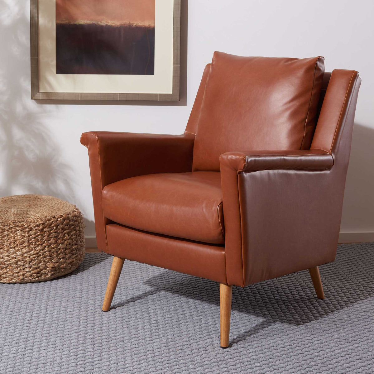 Cognac faux leather armchair adds warmth with soft cushions and tapered wood legs
