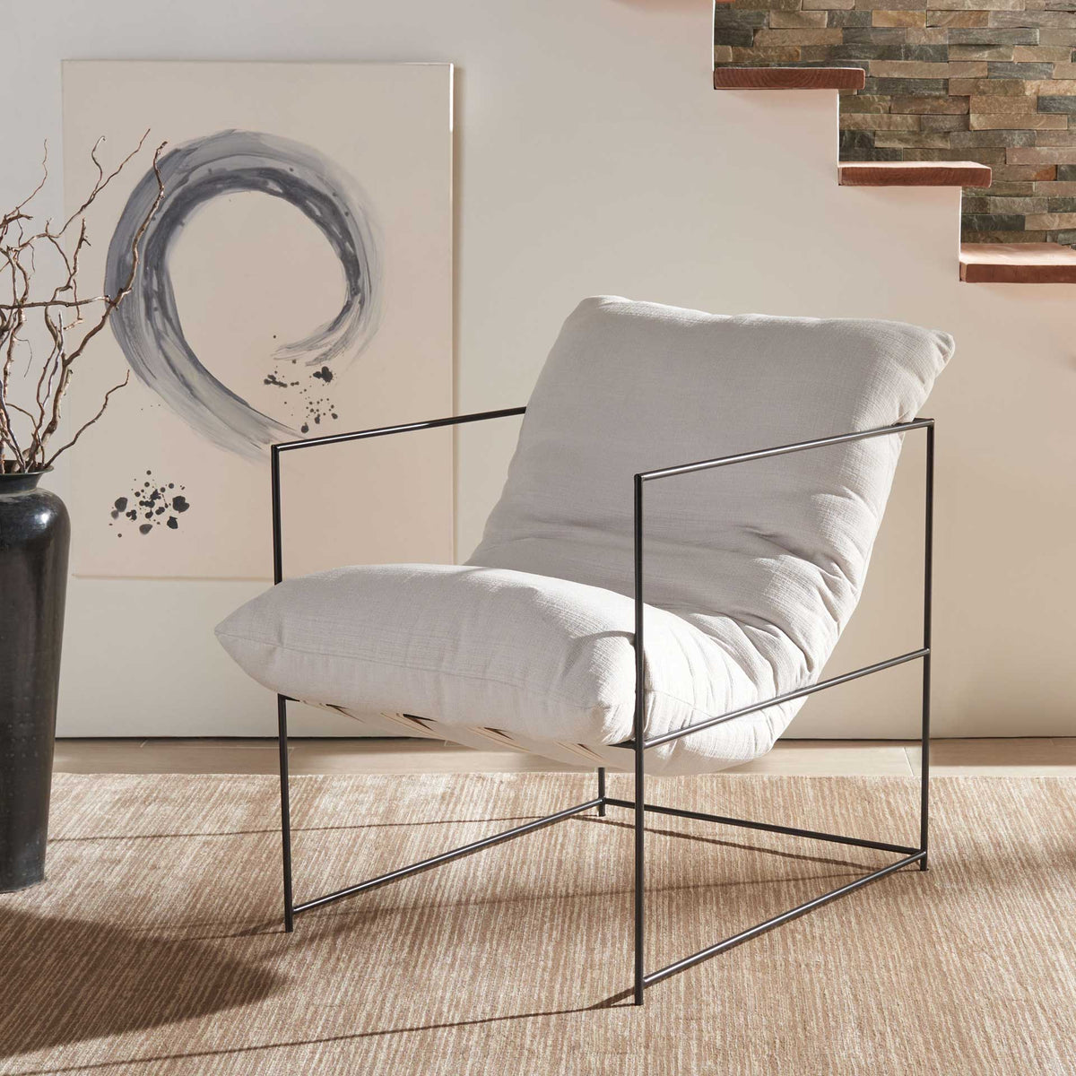 Generously cushioned ivory seating contrasts with the slender, open black iron frame.