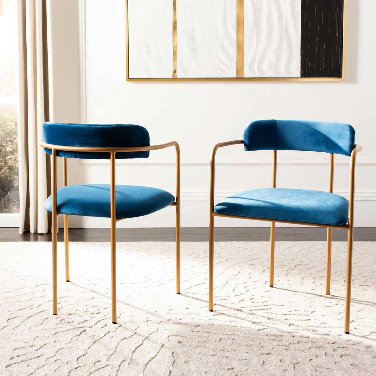 A coordinated pair of navy velvet chairs stands out with rich blue seats and gold frames