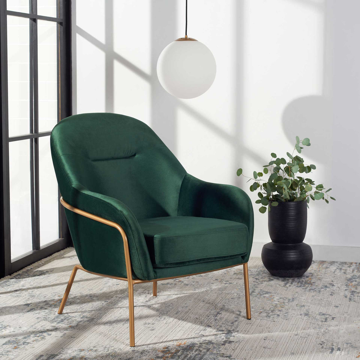 Deep green velvet and slender gold legs make a cozy statement in a bright interior.