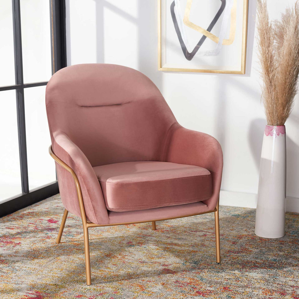 Dusty rose velvet adds warmth to a cozy corner, balanced by airy gold legs.