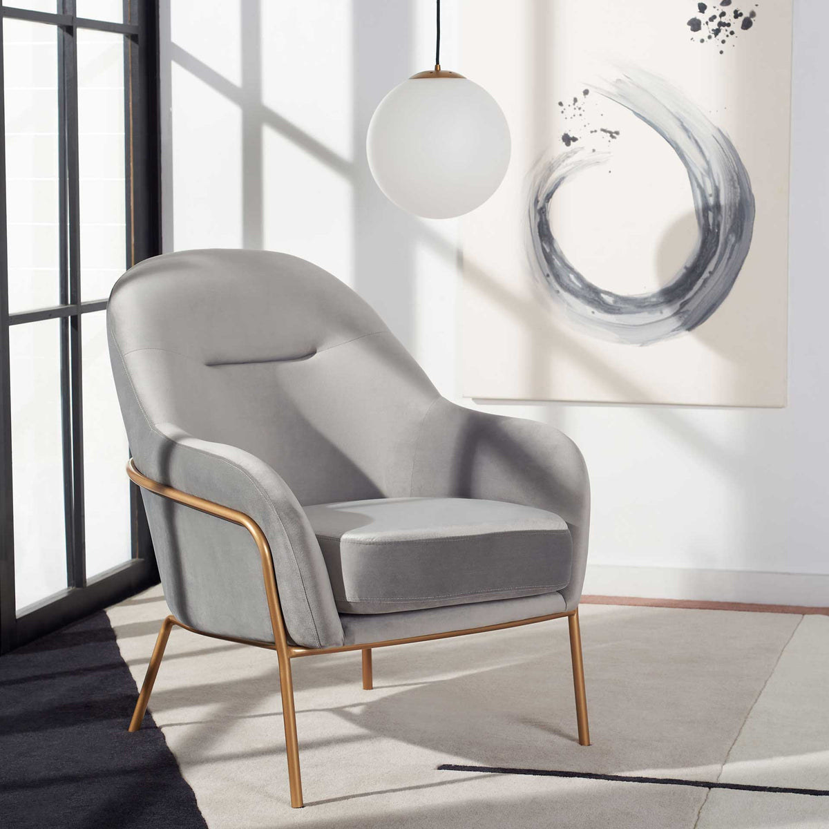Gray velvet upholstery and warm gold legs create an inviting spot to unwind.