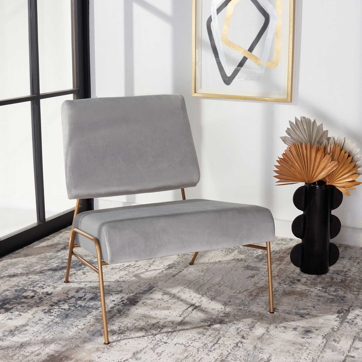 Gray velvet cushions and slim gold-finished legs bring relaxed, modern style to a room.