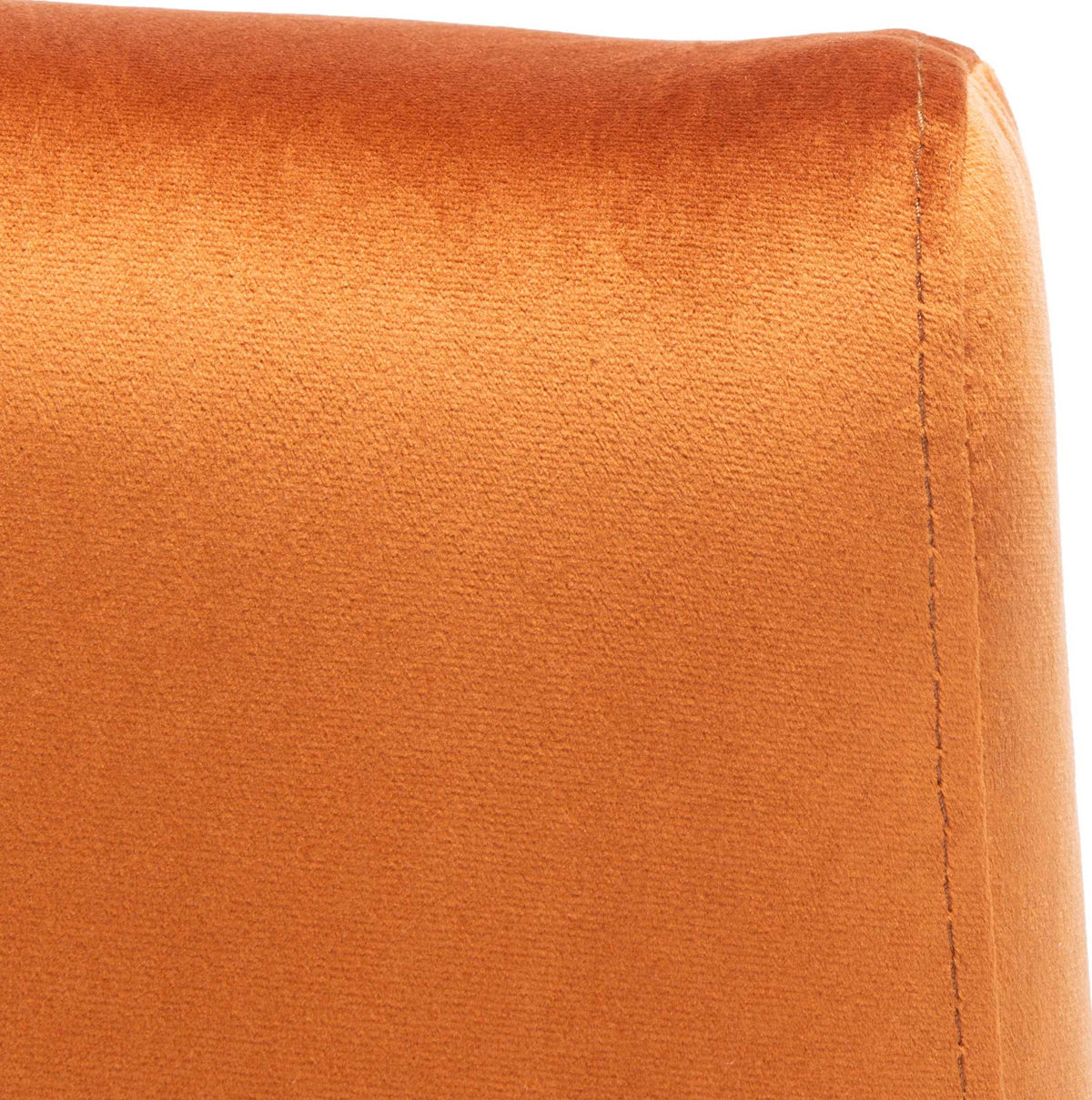 Warm sienna velvet has a soft sheen and a neat seam along the cushioned backrest.