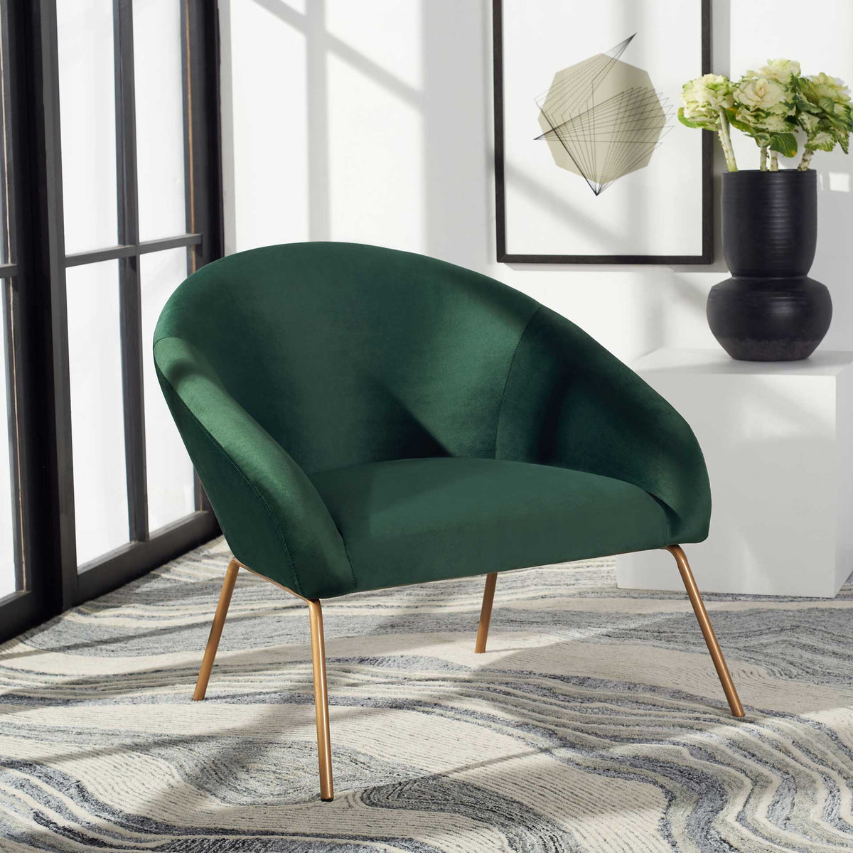 Deep green velvet and splayed gold legs give the sculptural accent chair a polished look