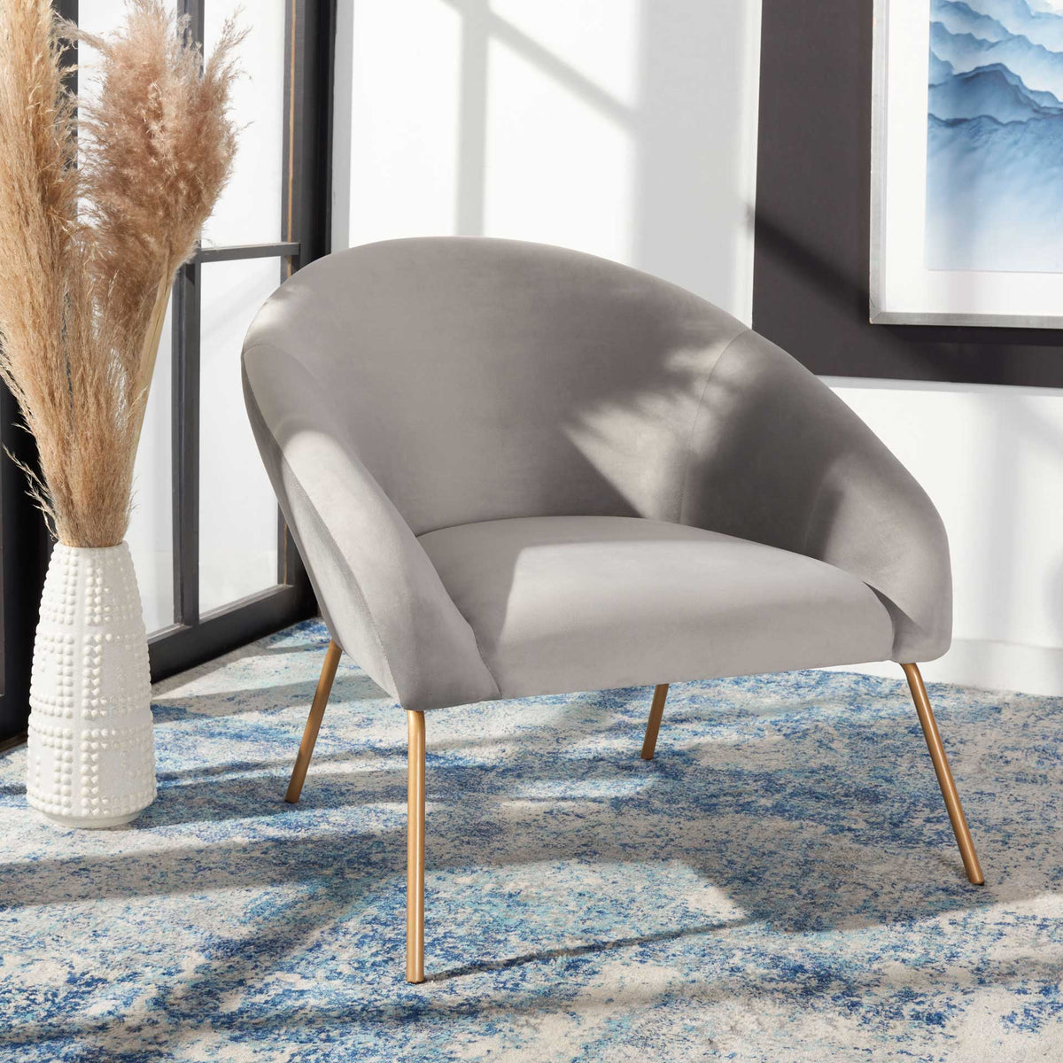 An inviting gray velvet seat and rounded back contrast with delicate gold legs