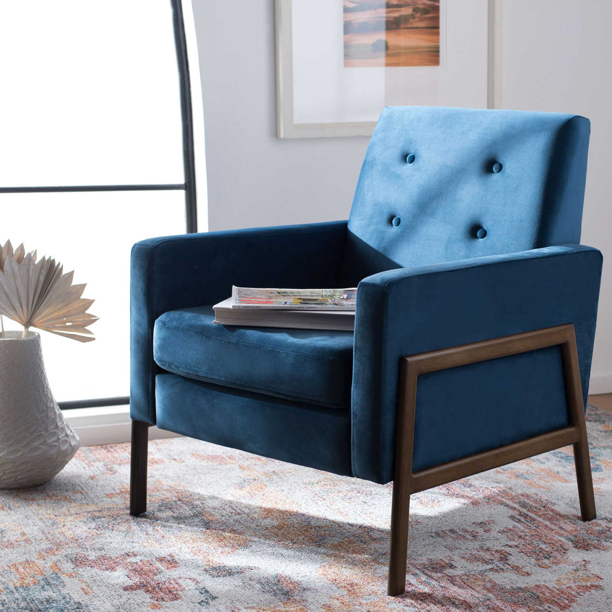 Blue velvet chair adds button-tufted comfort and warm coffee-tone framing to a cozy living space