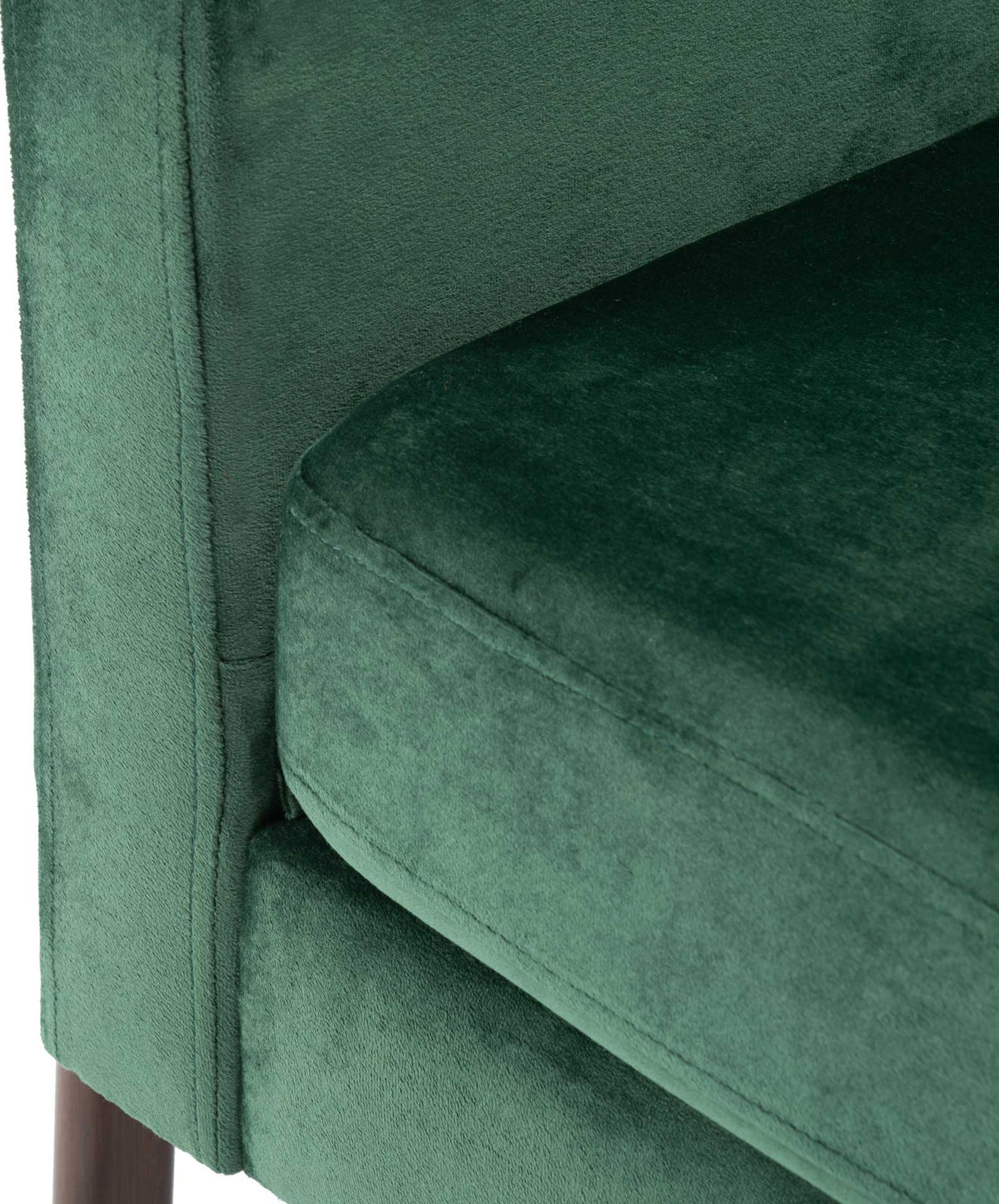 Green velvet seat cushion features tidy piping and soft upholstery along the arm and base