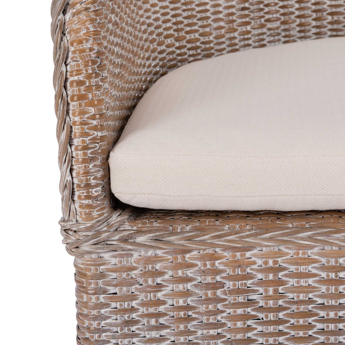 A soft white cushion nestles against the woven rattan arms and braided seat frame.