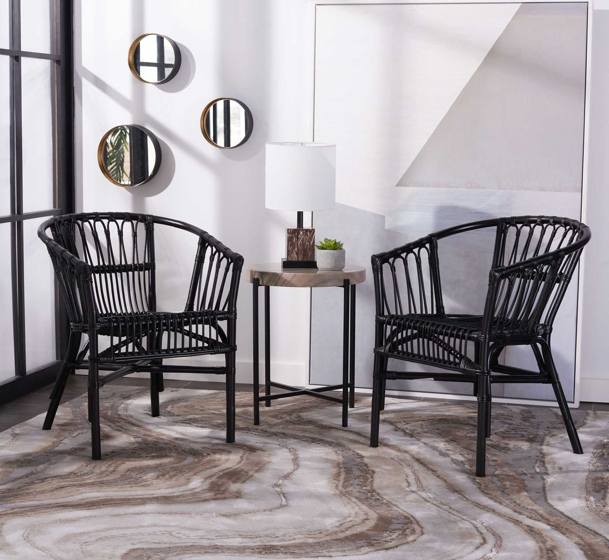 Matching black rattan chairs combine sweeping arms and open spindle backs for an inviting seating pair