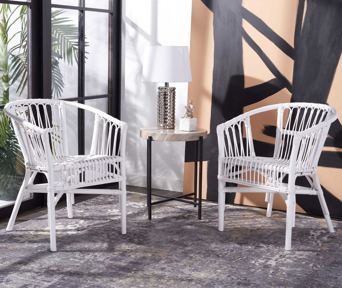 A pair of white rattan chairs adds sculptural curves and open woven texture to the seating area