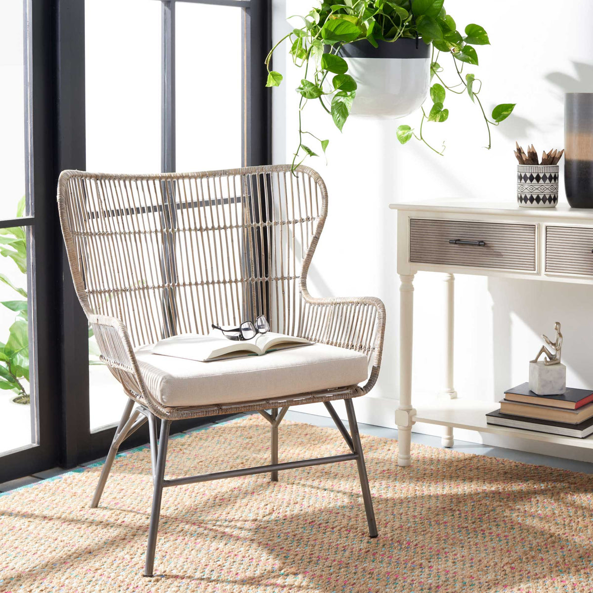 A whitewashed rattan fanback and plush white cushion lend inviting texture to a sunny sitting area
