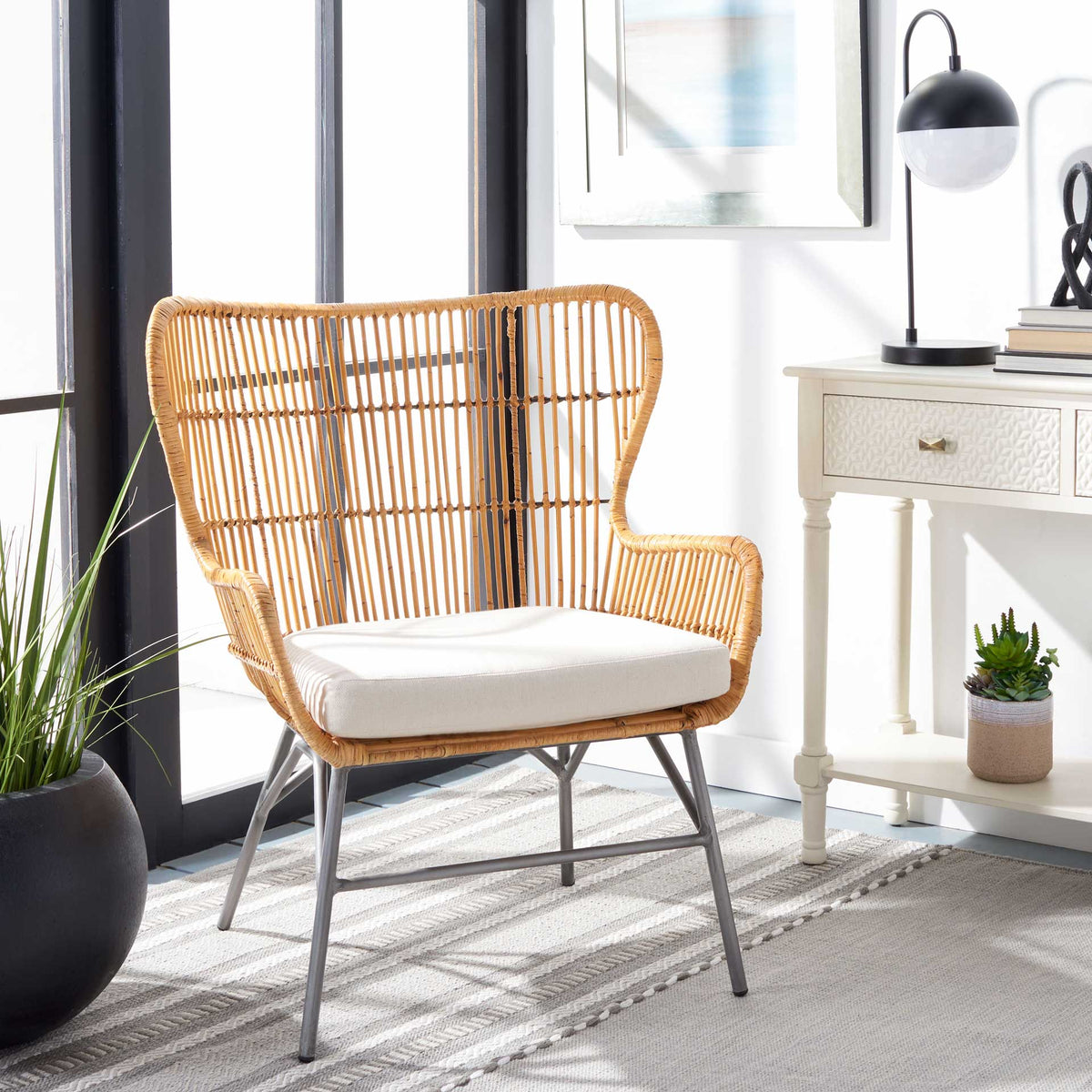 Honey-toned rattan, a white cushion, and angled metal legs add warmth to a bright sitting area