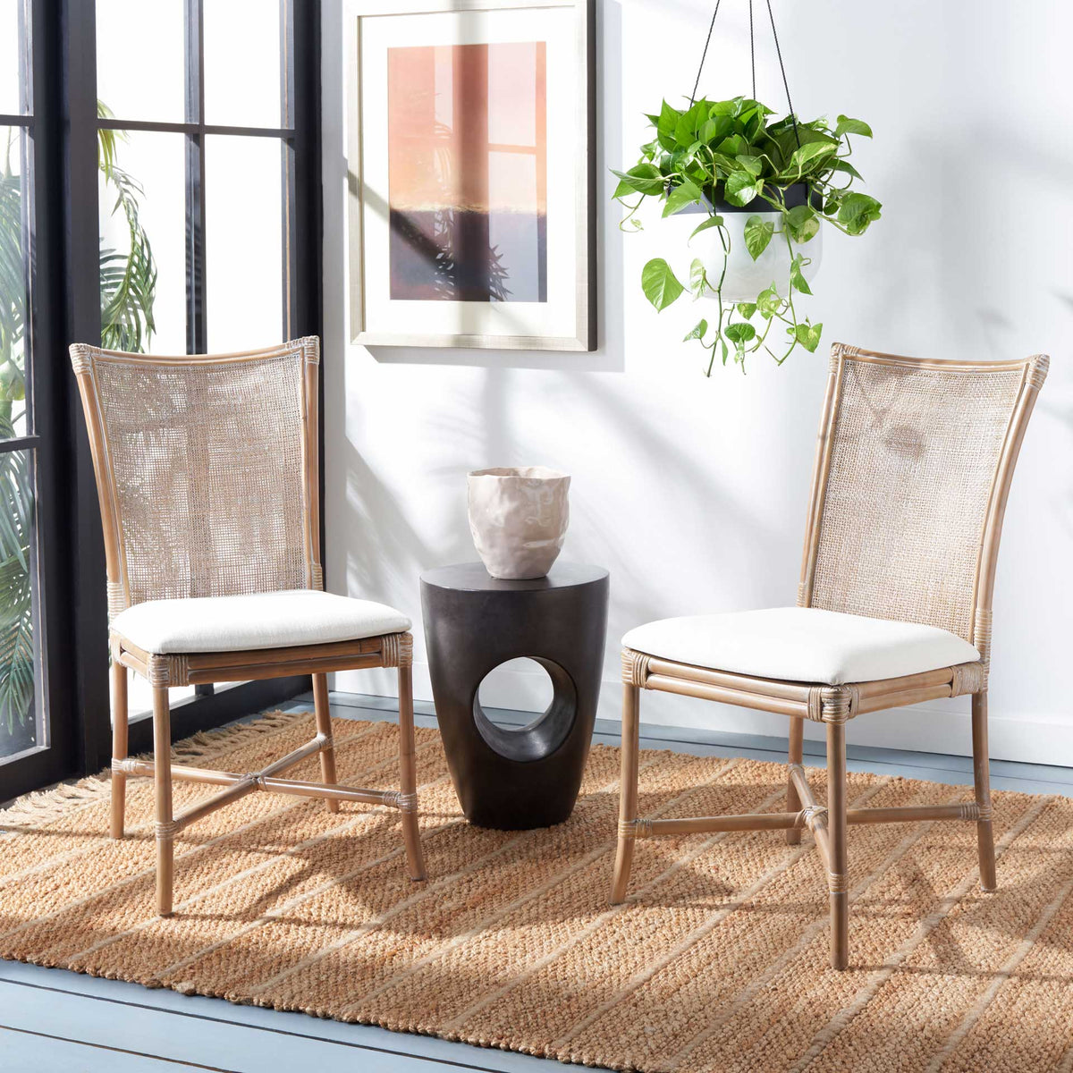 Two woven rattan chairs with white cushions create an inviting coastal seating area