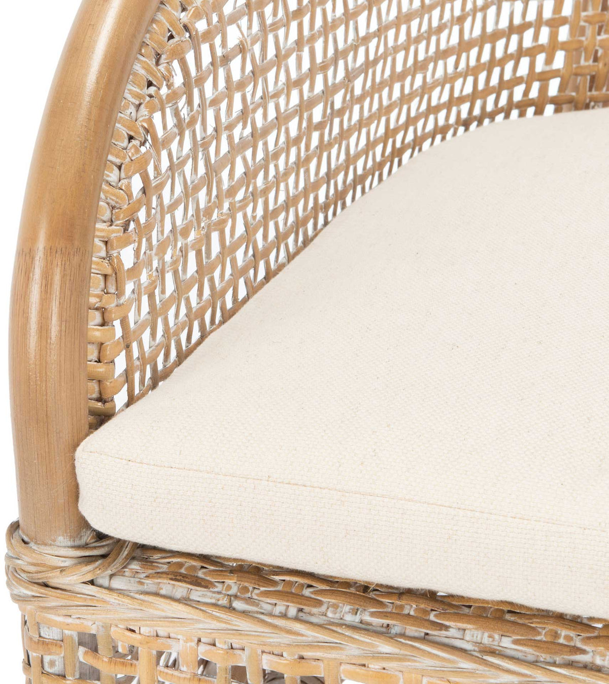 A white cushion nestles against a curved rattan arm above woven trim with a pale washed finish.