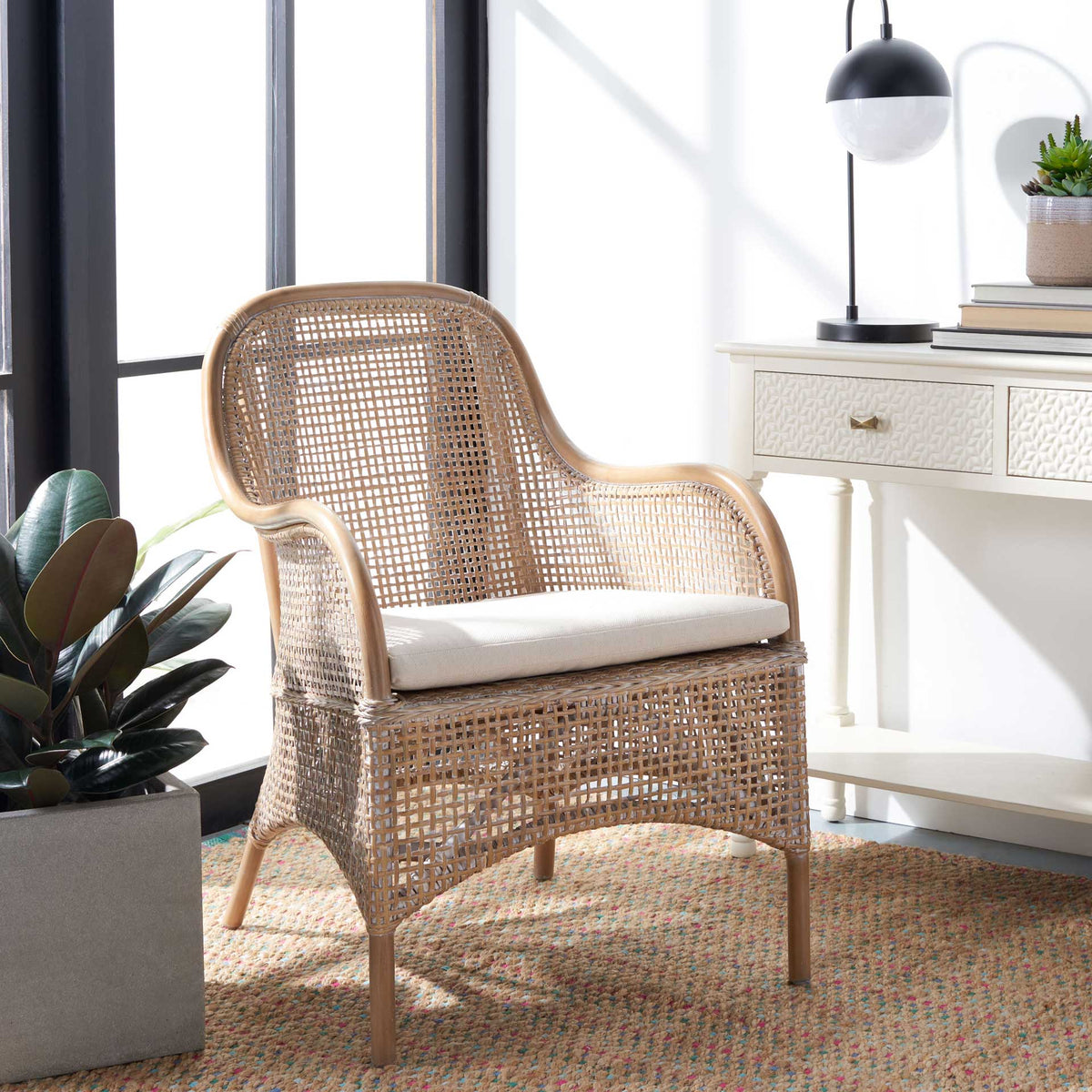 Pale woven rattan and a white seat cushion give this curved accent chair an inviting coastal feel.