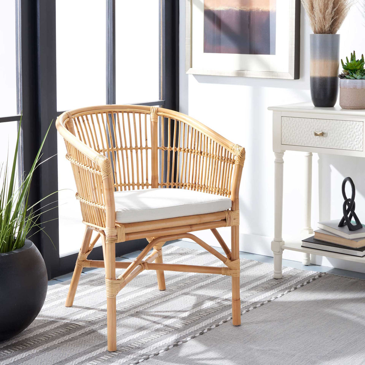 A natural rattan chair brings a curved back and soft white seat cushion to a sunlit room.