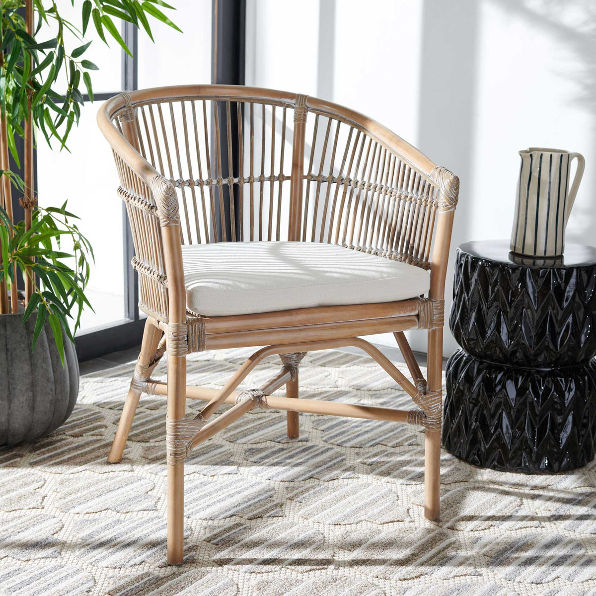 A gray-whitewashed rattan barrel chair lends woven texture and a cushioned seat to a bright living space.