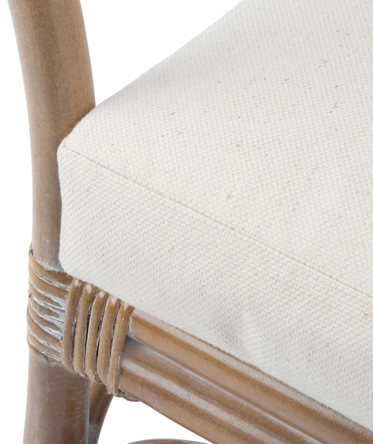 Textured white seat cushion meets neatly wrapped rattan joints and a pale washed frame