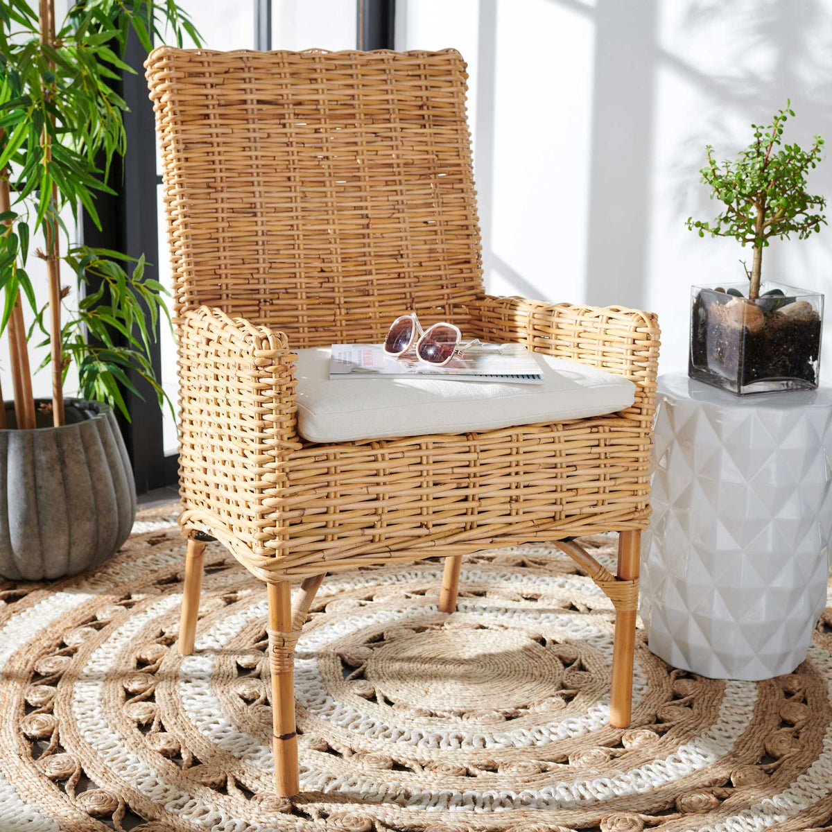 A natural rattan chair with a white cushion adds airy texture and warmth to a relaxed living space.